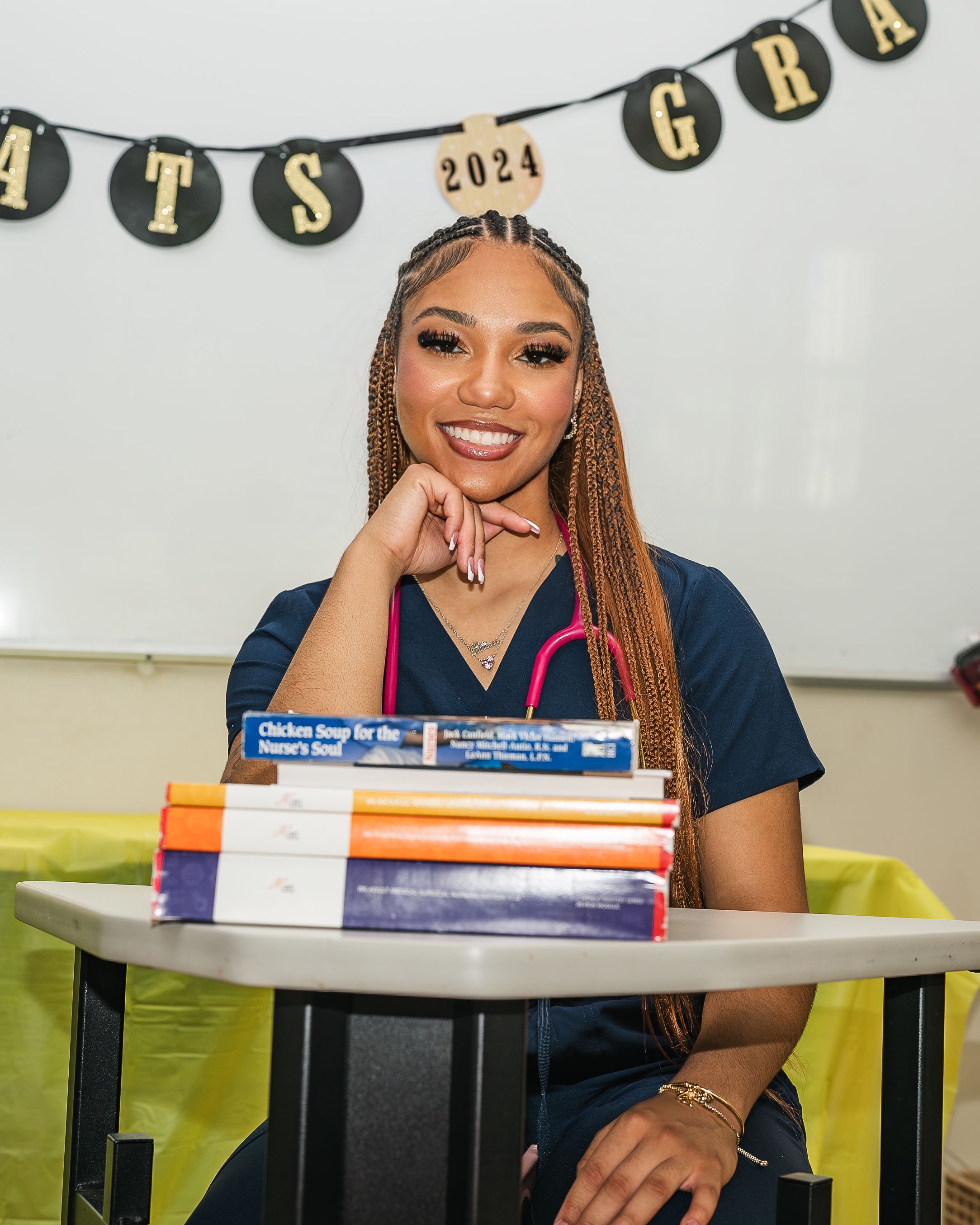 Alissa Crafton smiling in navy scrubs with a pink stethoscope